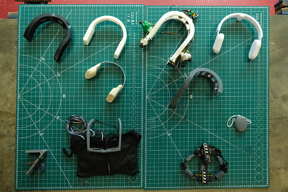 A selection of prototypes for a wearable device laid out on a green cutting mat.