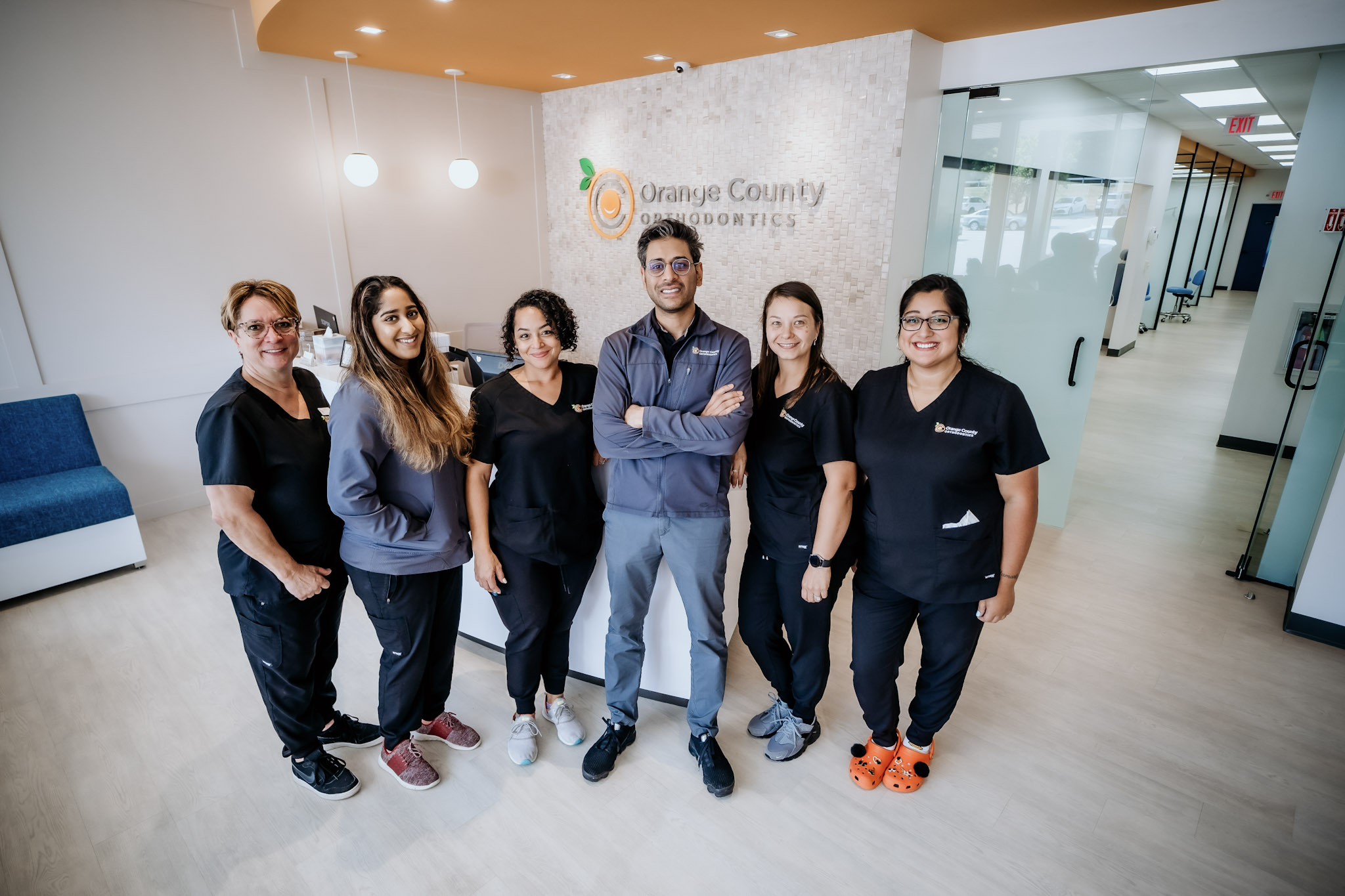 Orange County Orthodontics staff with Dr. Patel in the office hallway