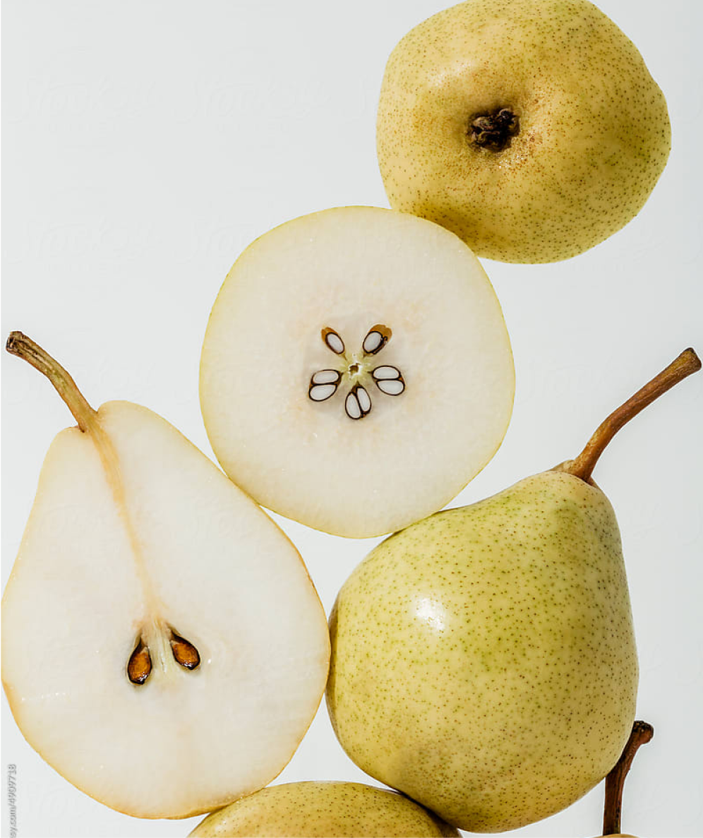 Several pears stacked some have been cut open to allow you to see the core