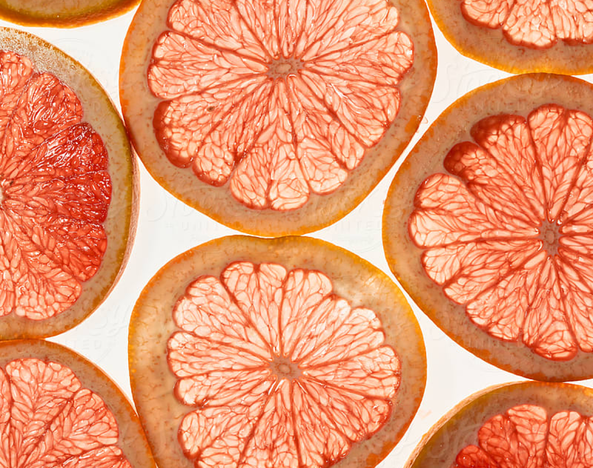 Sliced grapefruit stacked vertically within the frame