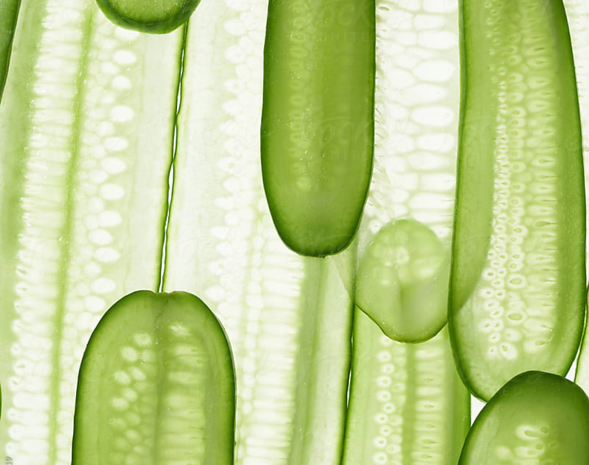 Upclose shot of thinly sliced cucumbers stacked vertically on top of each other