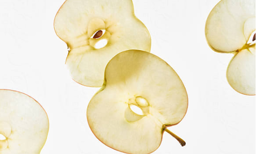 Shot of vertically sliced apples moving in and out of frame