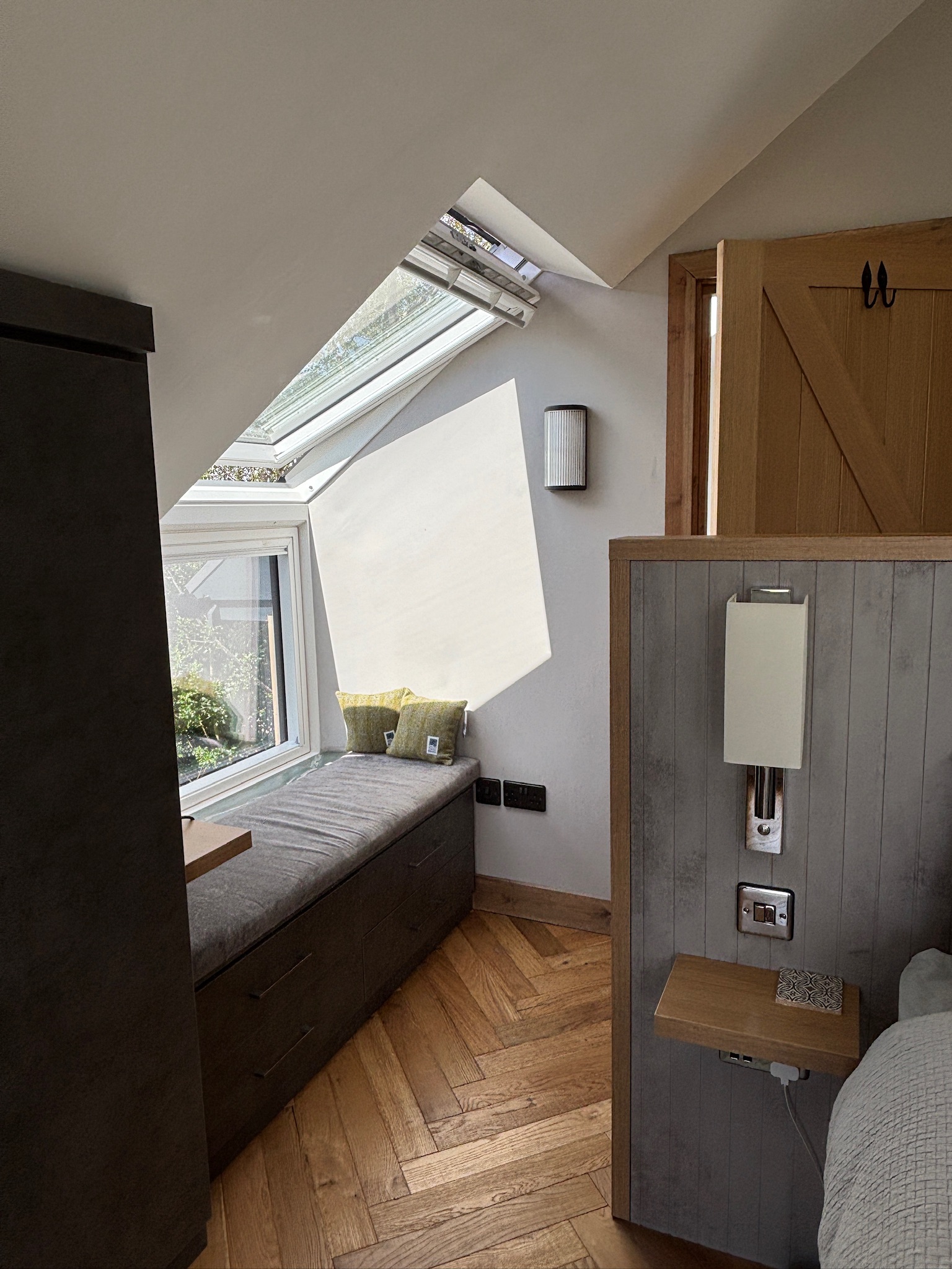 Master bedroom with window seat and wrap around roof light.