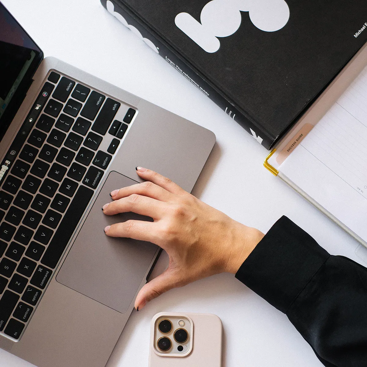 Hand on laptop creating custom blog content as part of SEO blog writing services for small businesses.