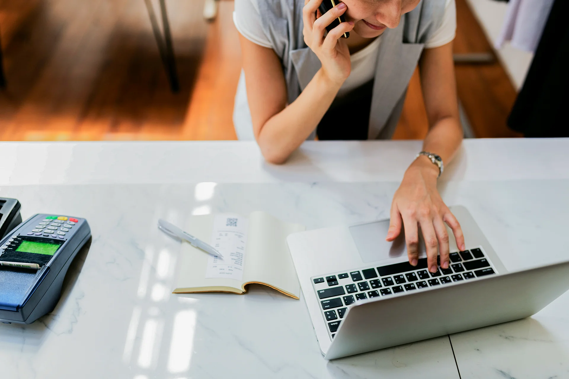 Small business owner on phone while researching website design options on a laptop