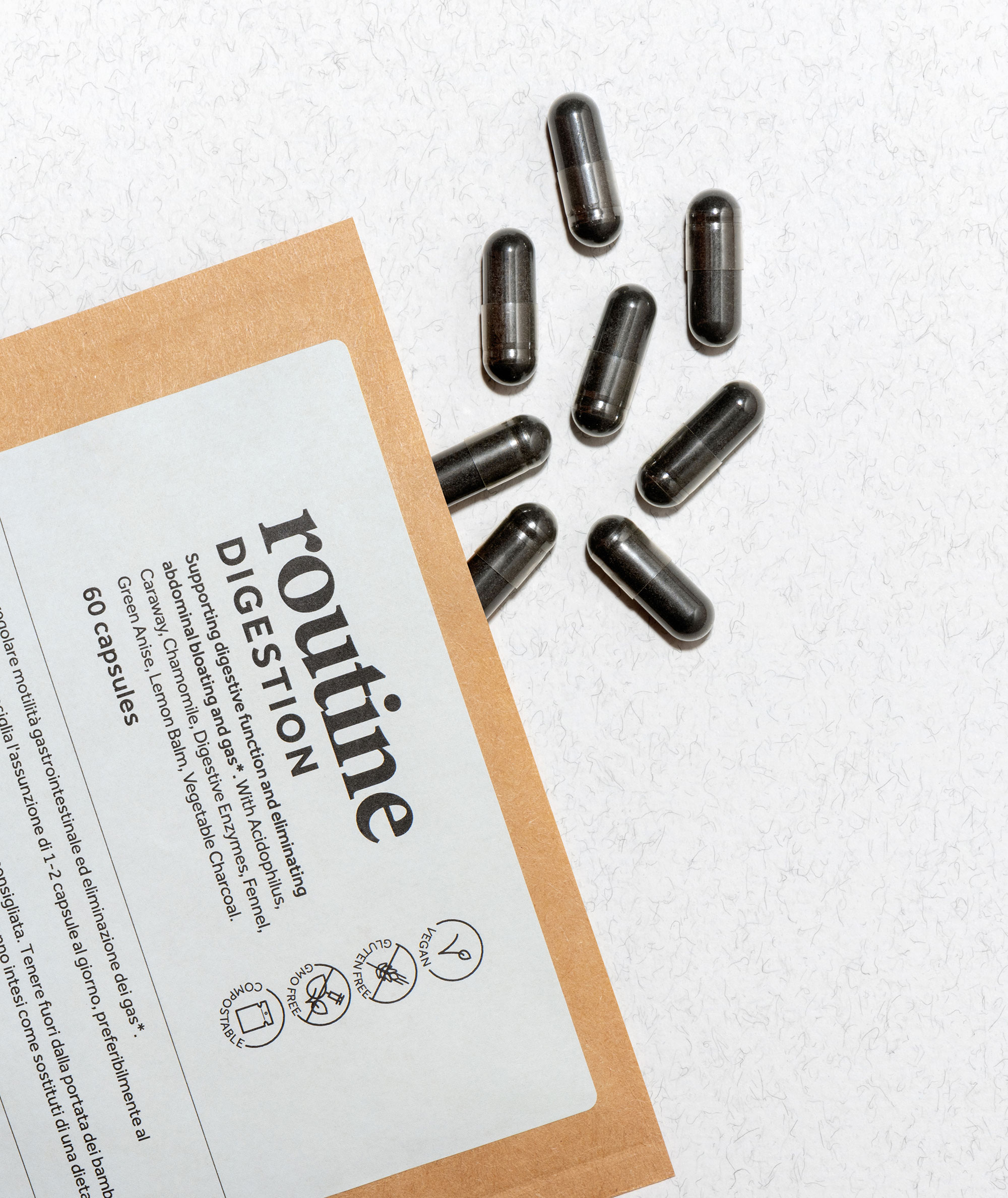 A nutritional supplement sachet open on surface showing dark capsules