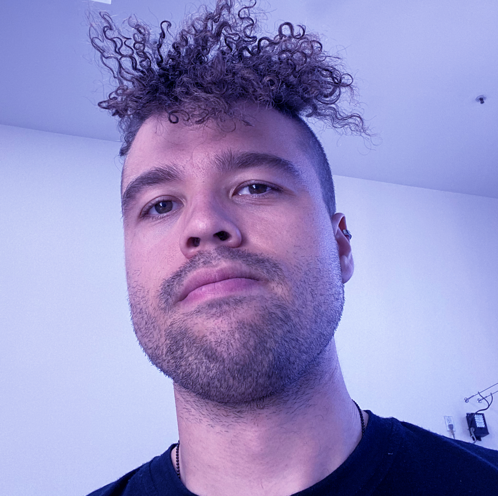 Portrait of Kai Daniels. Curly hair. Cute face. Cute AF.