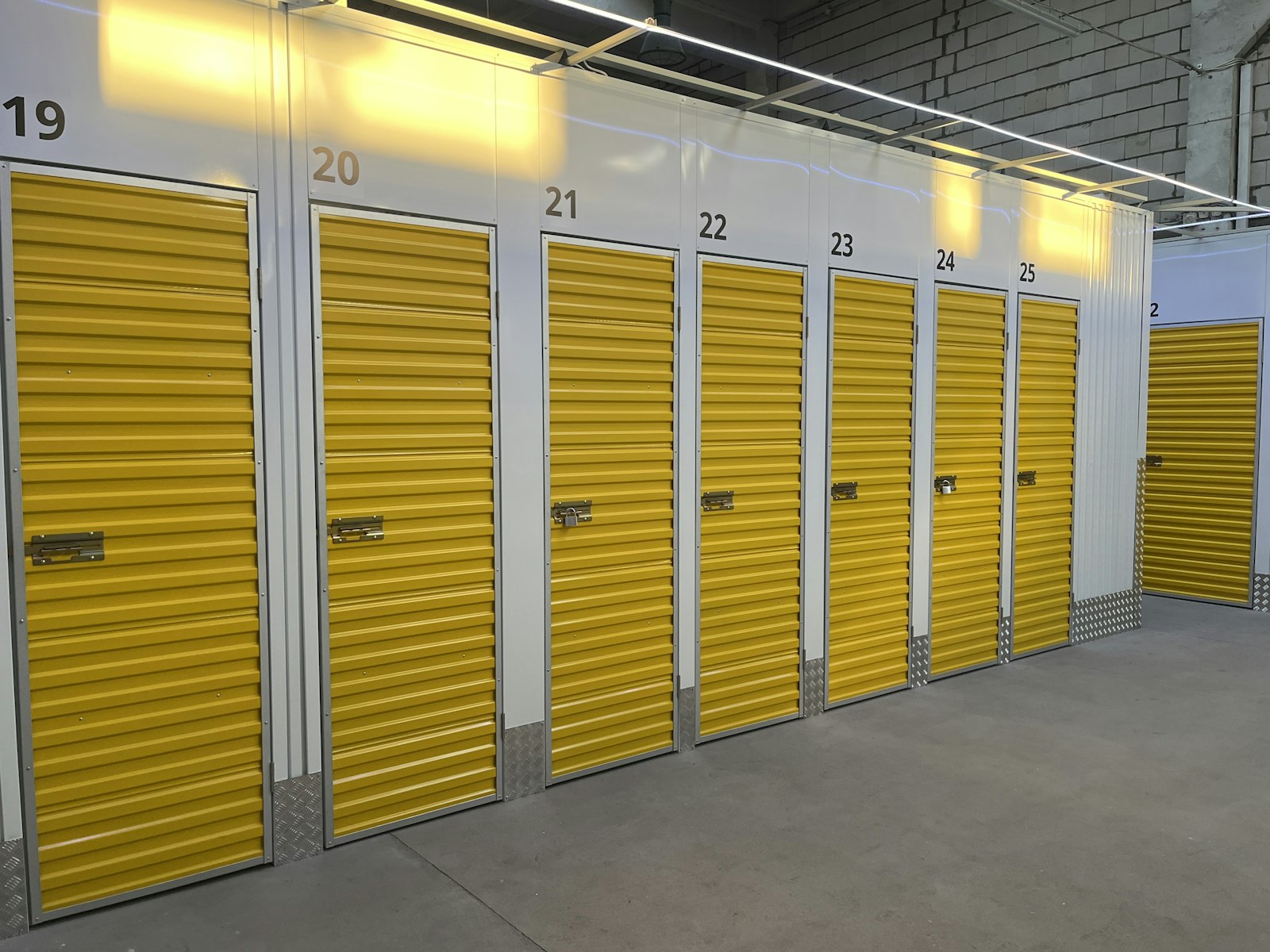 Corridor of self storage units with yellow roller doors