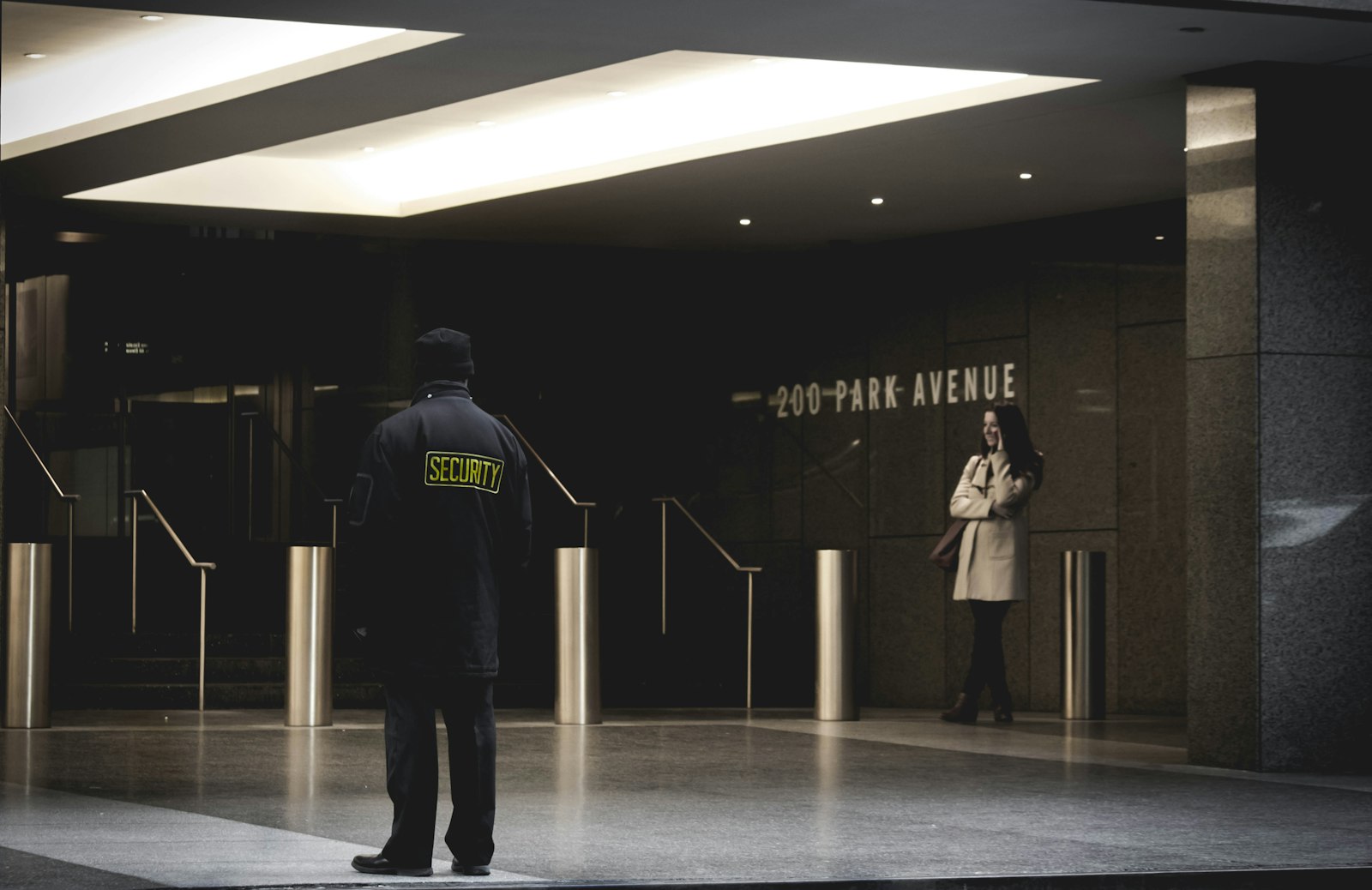 Uniformed security guard standing at a lobby post