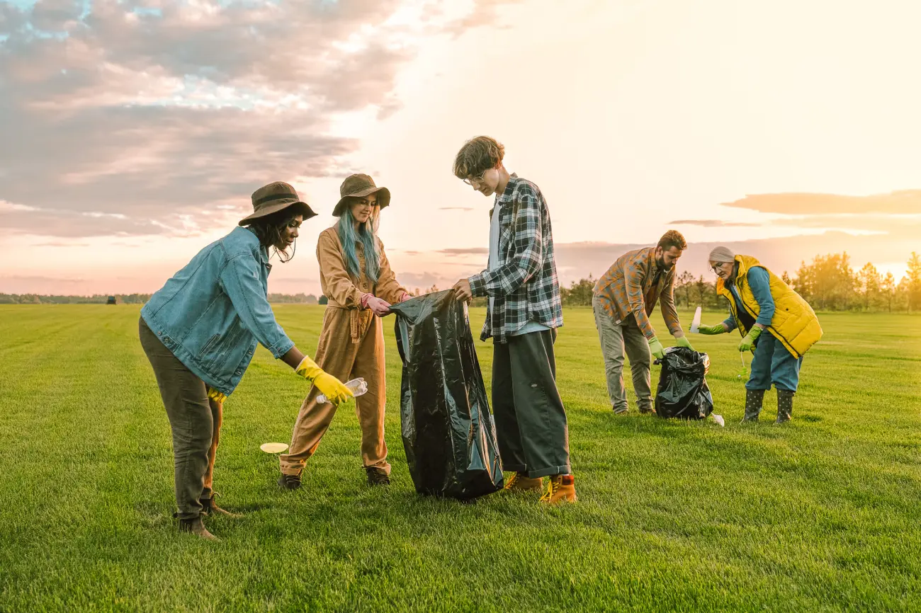 volunteers picking up trash in a field