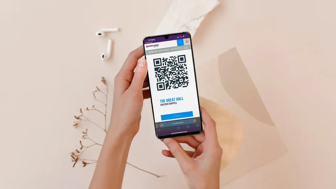 Person holding a phone showing Event.Gives ticketing