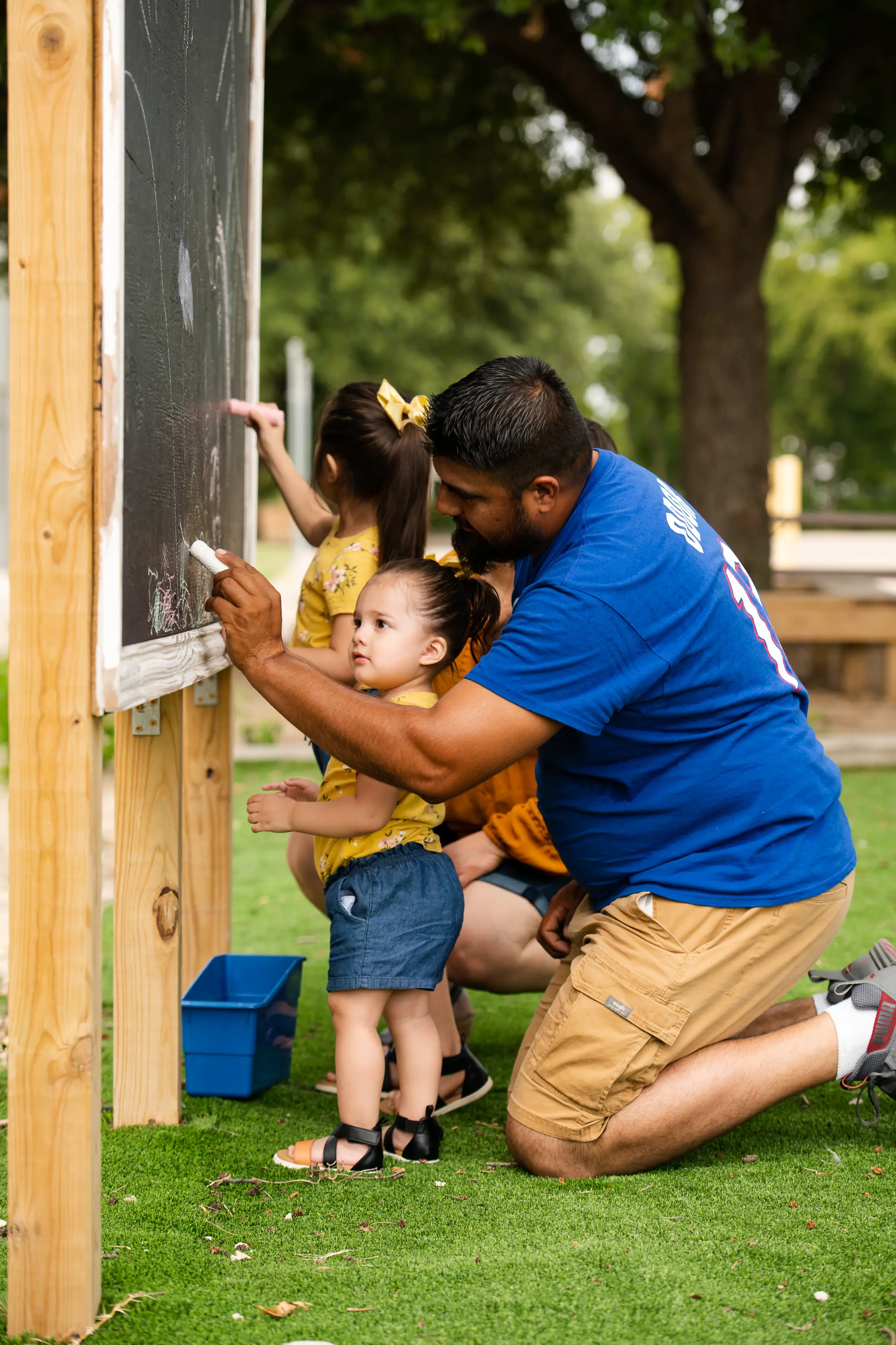 father drawing with daughter on chalkboard