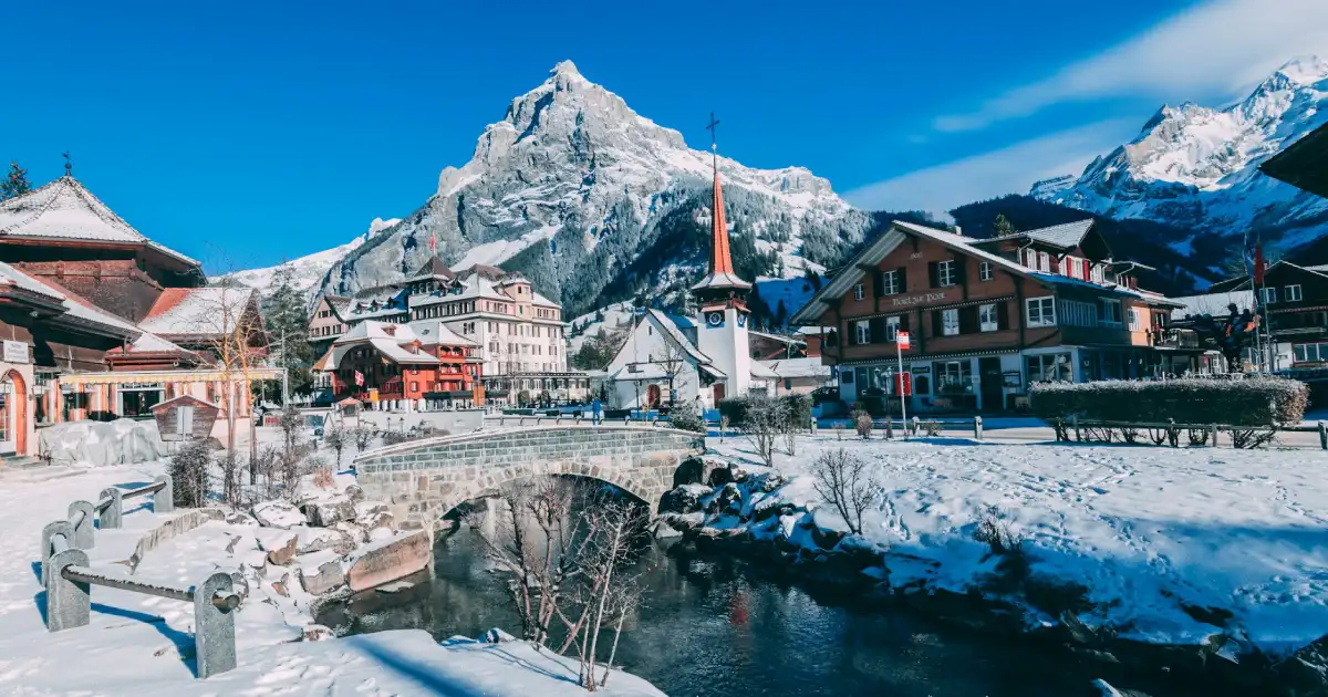 Alpes suíços cobertos de neve com vila suíça em primeiro plano