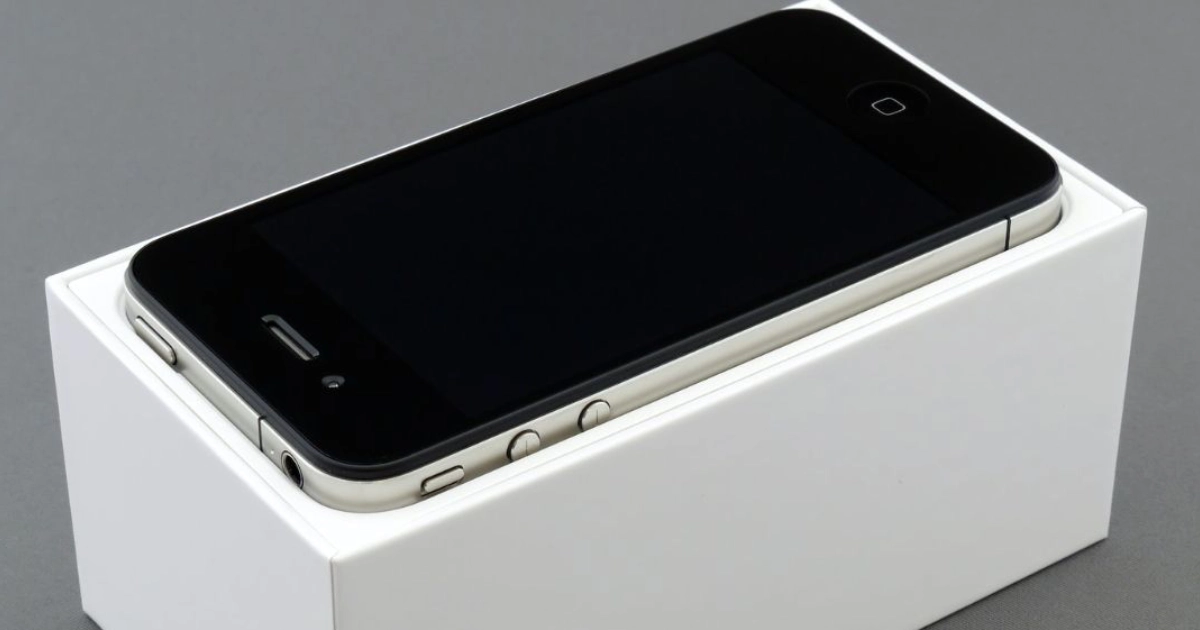iPhone preto com a tela desligada em cima de uma caixa branca