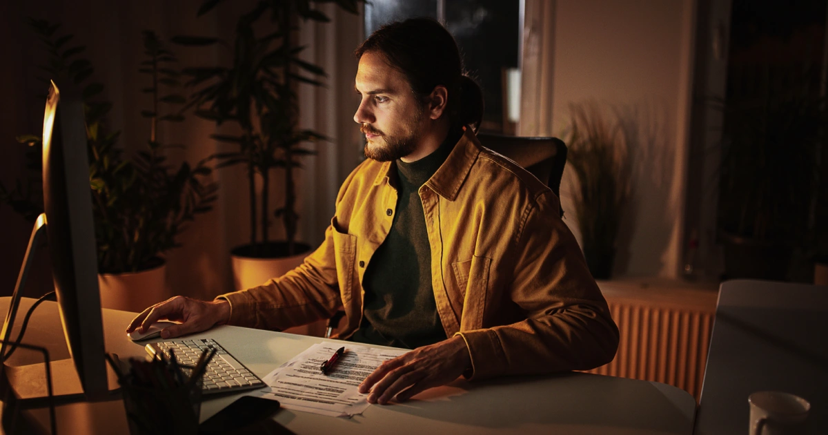 Homem sentado à frente de um computador trabalhando