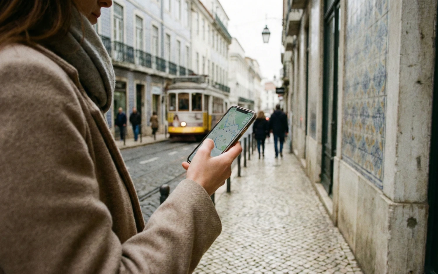 Mulher usando celular em rua de Lisboa