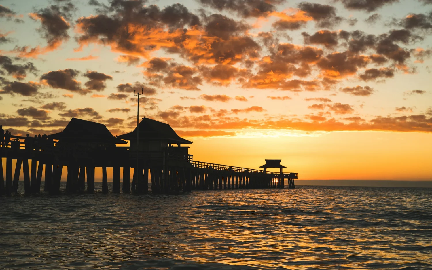 Píer sobre mar durante pôr do sol