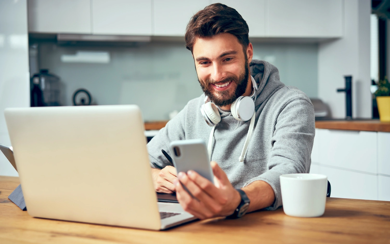 Homem usando notebook e celular