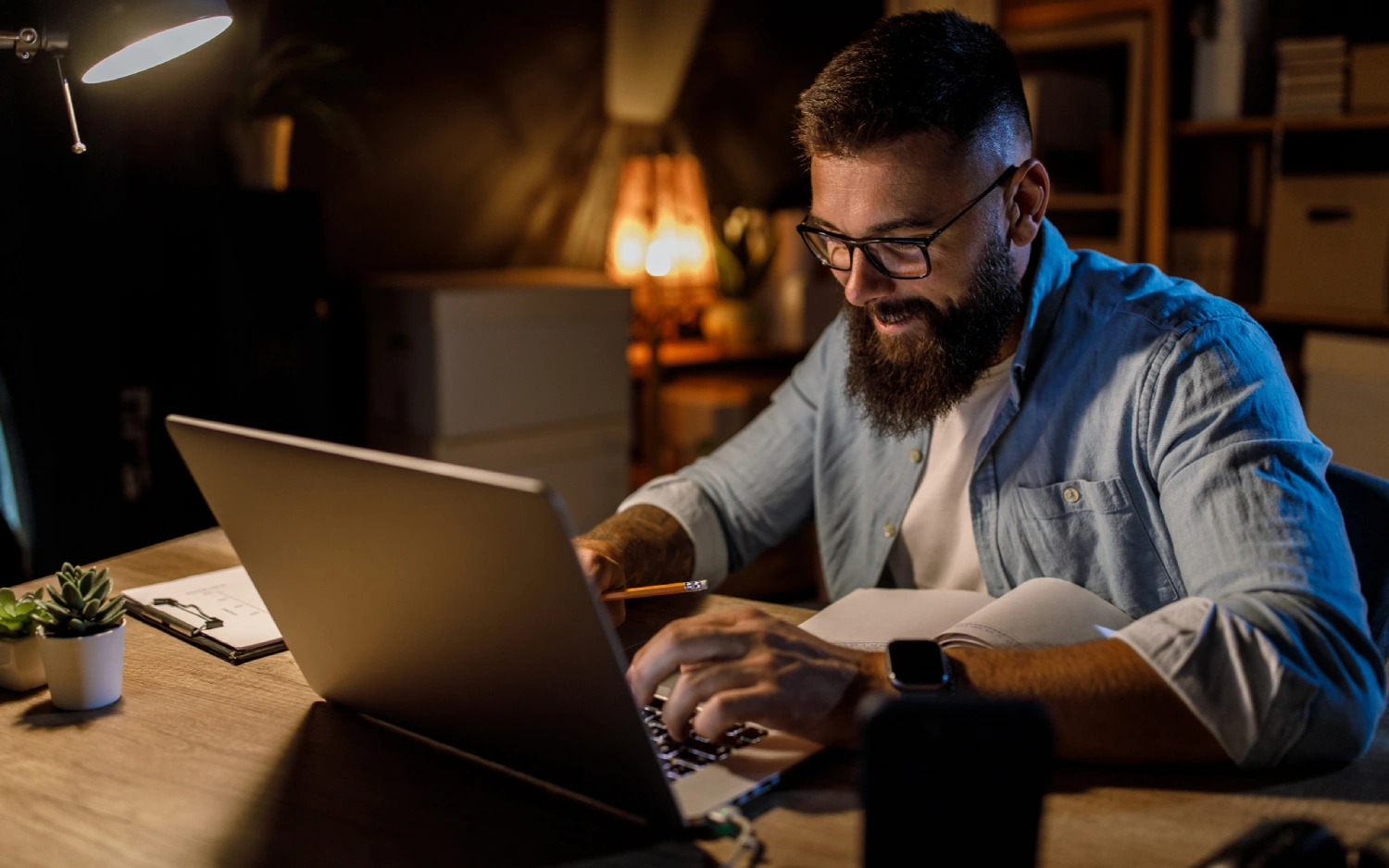 Homem branco com camisa azul usando notebook