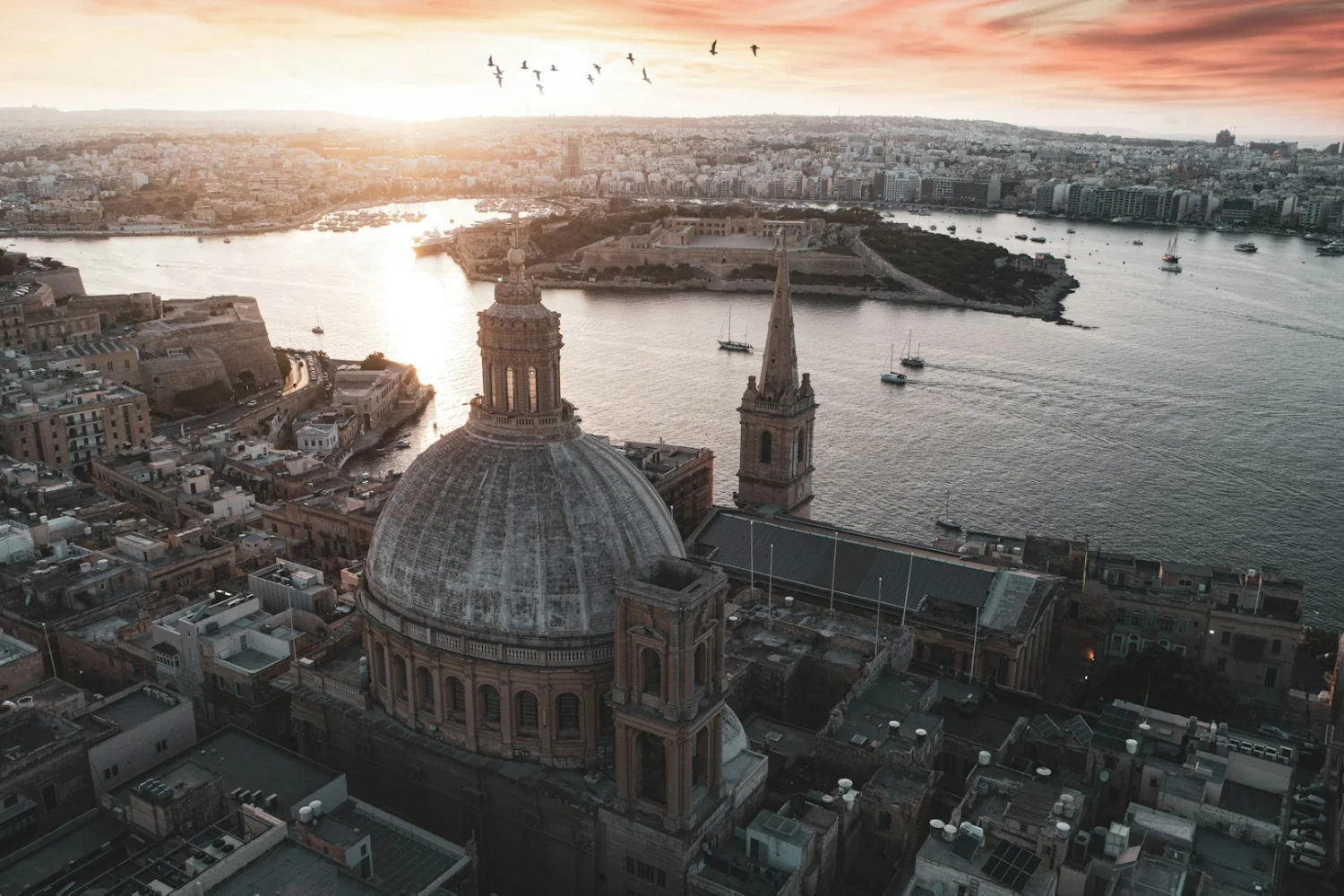 Edifício de cúpula marrom e branca perto de baía em Valletta,
