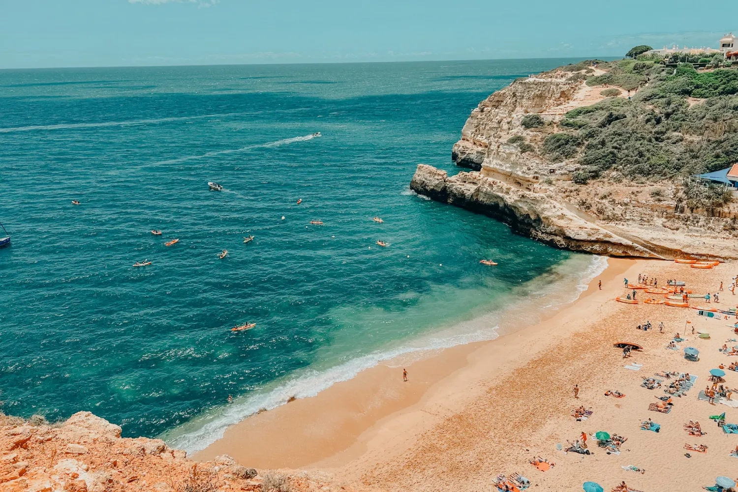 Faixa de areia com banhistas na Praia da Marinha, em Algarve