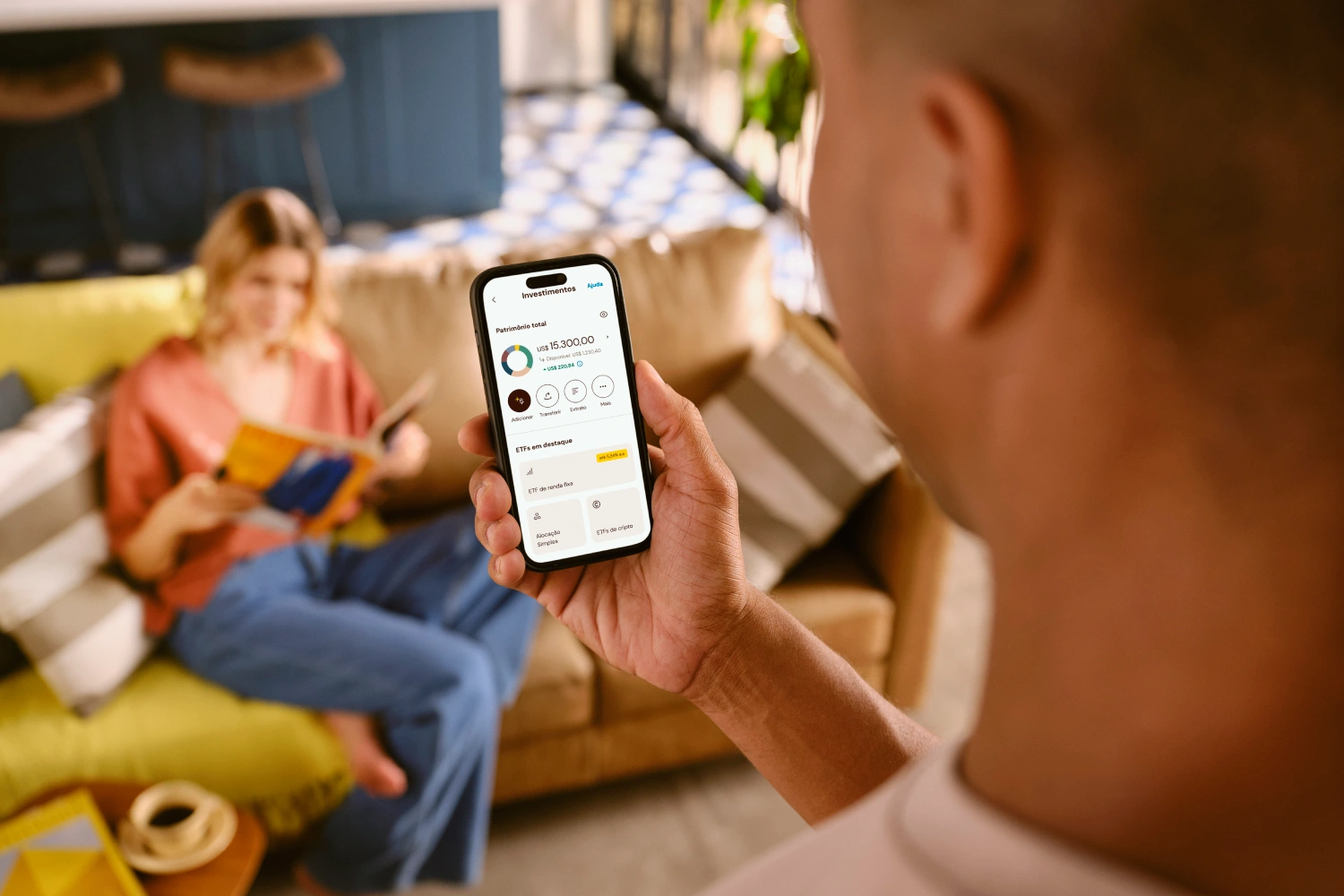 Homem visualizando saldo e transações no aplicativo Nomad pelo celular depois de abrir uma Conta Internacional usando um cupom de desconto Nomad