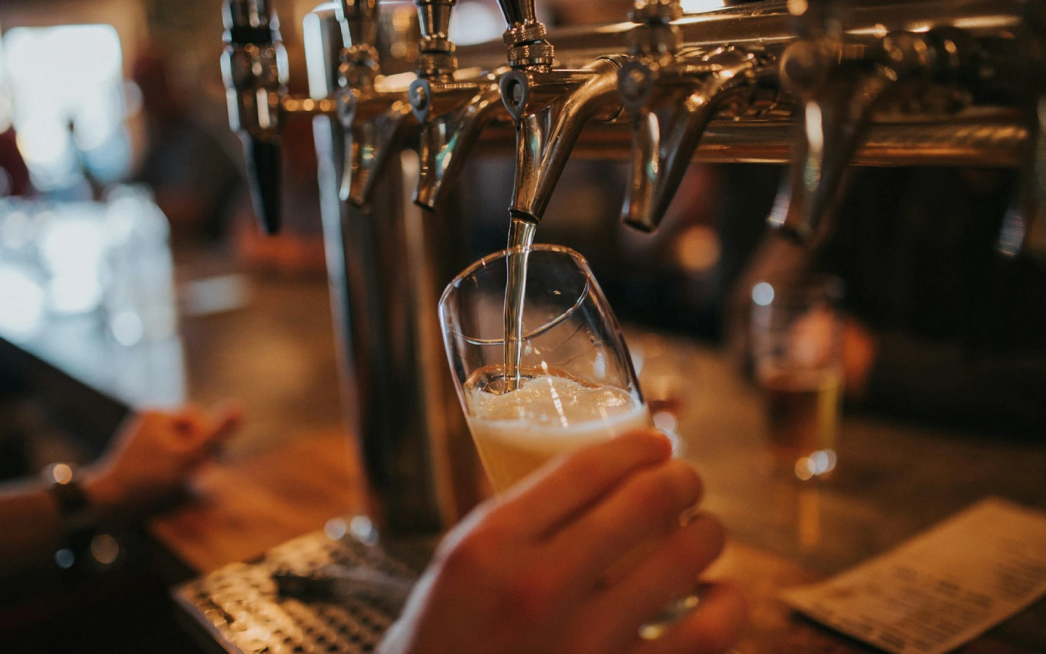 Pessoa enchendo copo com cerveja em um bar de Chicago