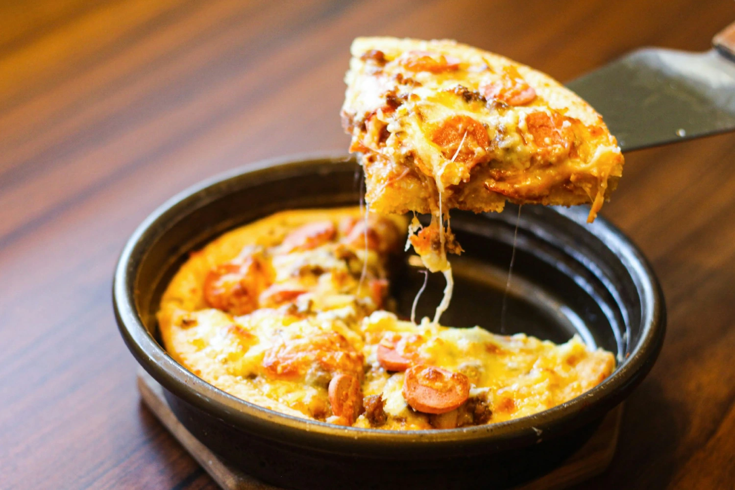 Deep dish pizza sendo fatiada