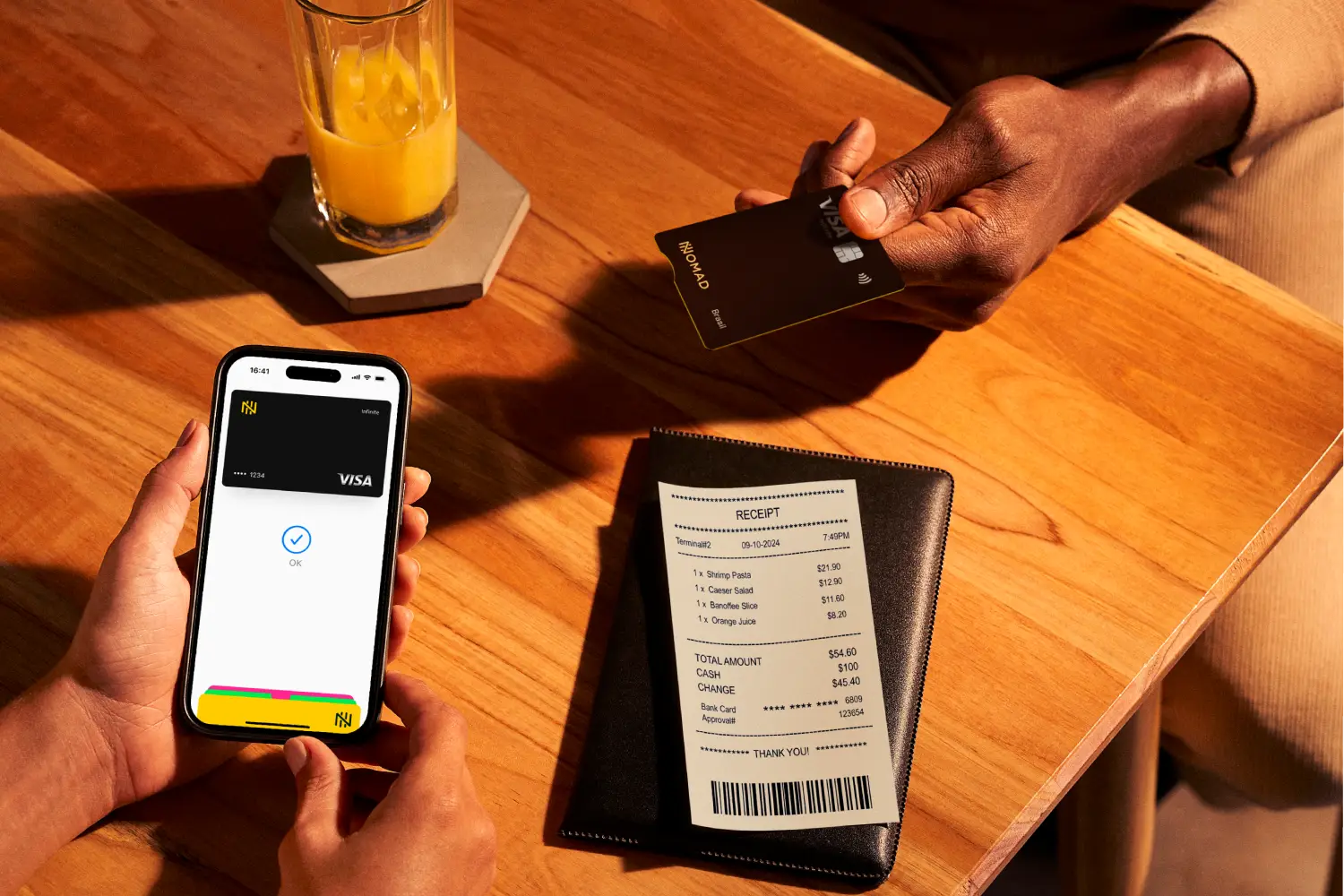 Detalhe em pessoa usando o Cartão de Crédito Nomad Explorer para fazer um pagamento