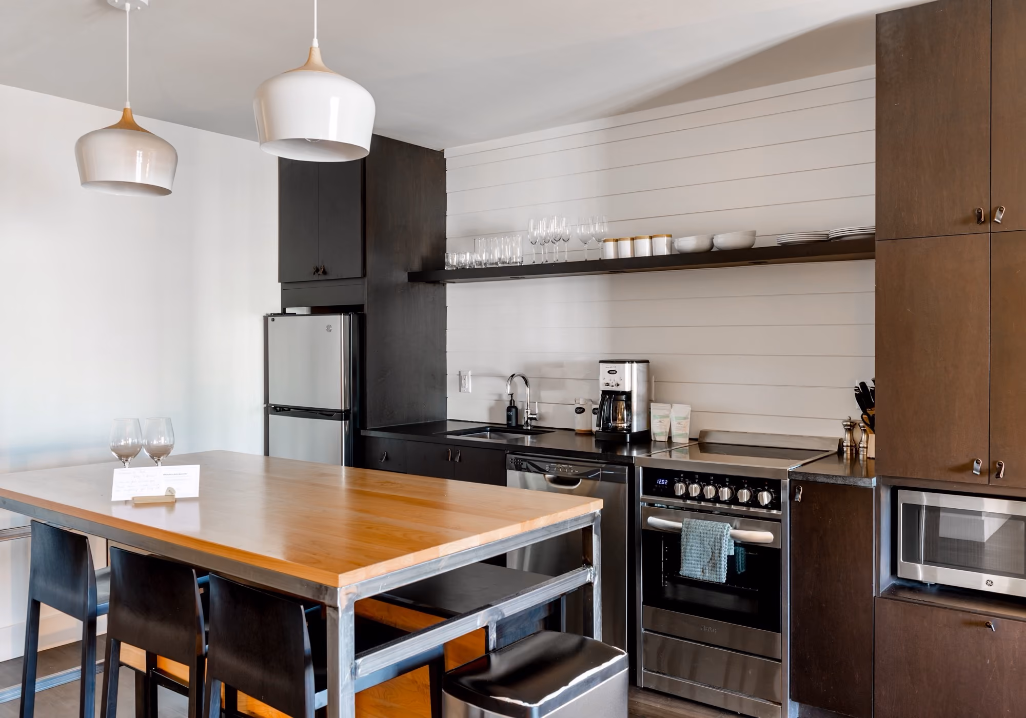 Fully equipped kitchen with dining island, oven and open shelving in a two-bedroom premium suite