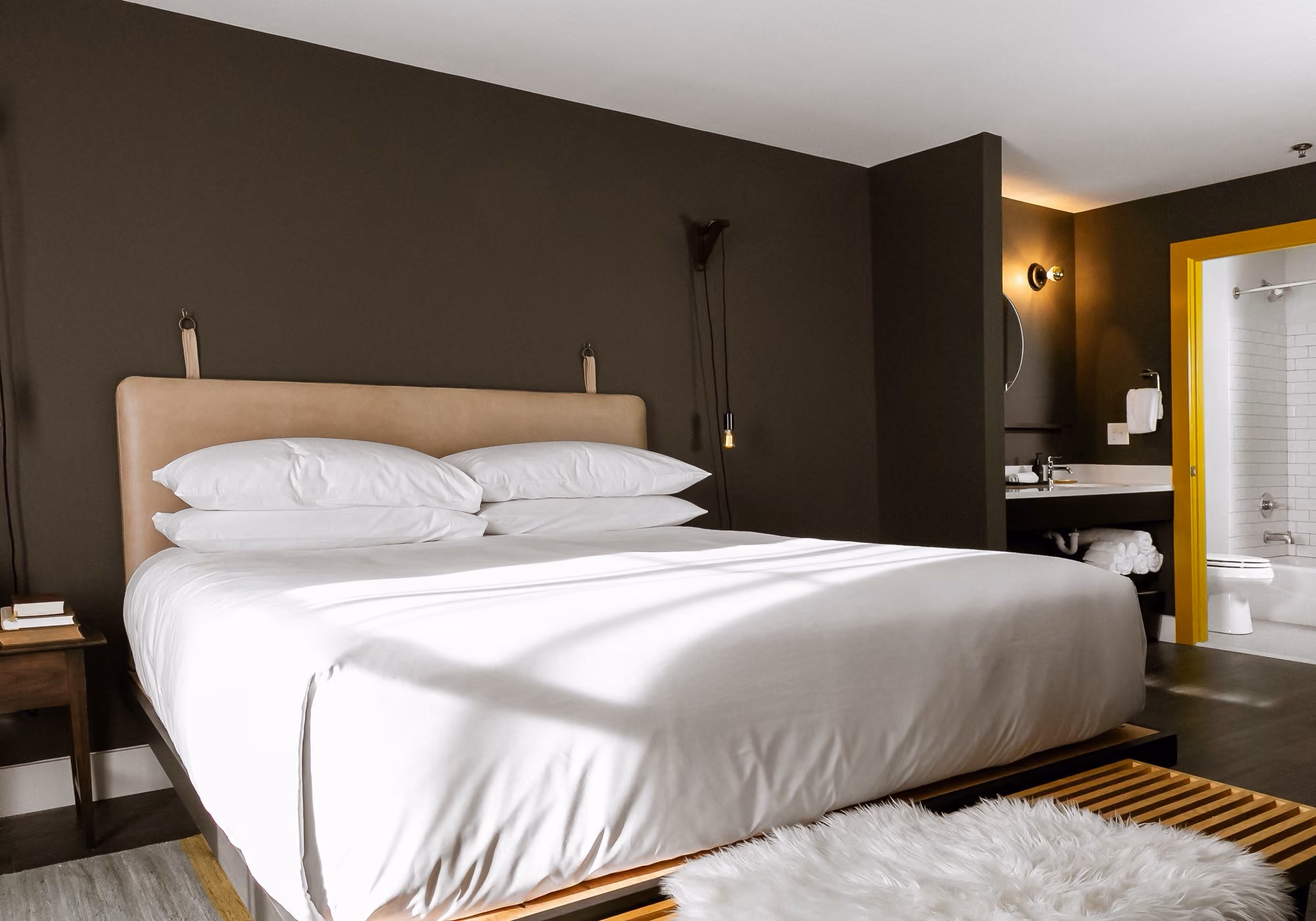Bedroom with king bed, leather headboard and ensuite bathroom in a three-bedroom suite