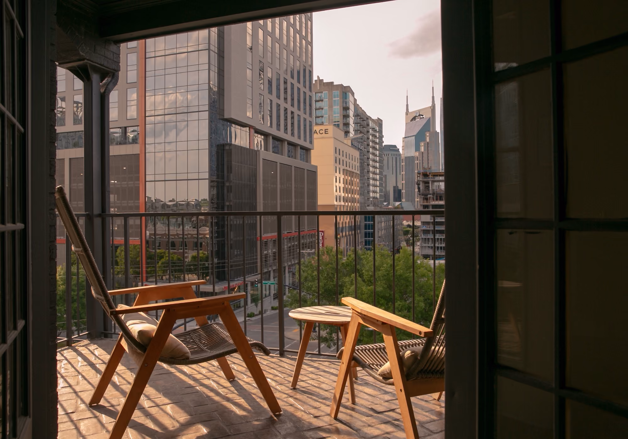 Private balcony with wooden lounge chairs overlooking the downtown Nashville skyline