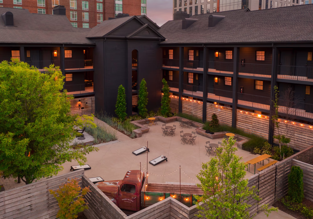 Bode Nashville hotel exterior at twilight with glowing balcony lights around the courtyard