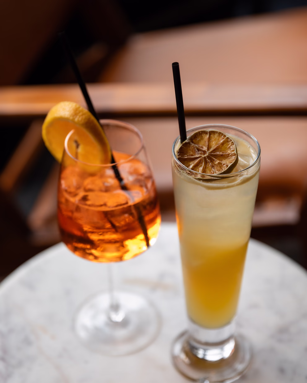 Orange spritz and citrus highball cocktails on a marble table at Sidebar bar in Nashville