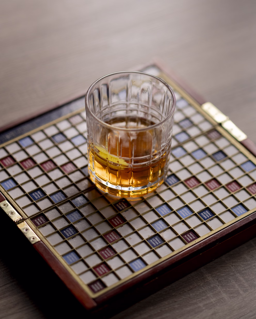 Whiskey in a crystal glass on a vintage Scrabble board at Sidebar bar