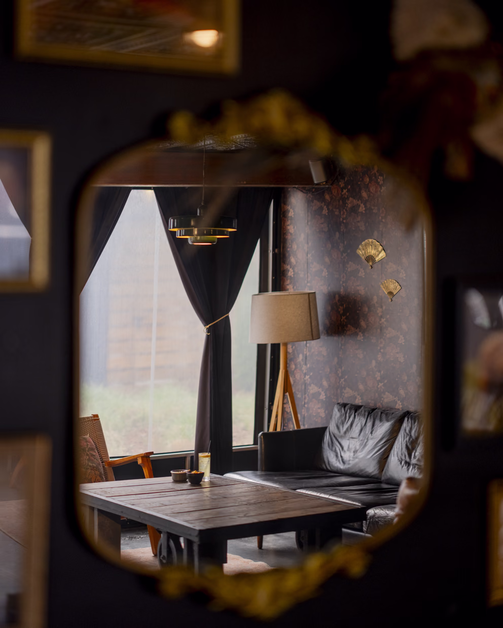 Sidebar cocktail lounge seating reflected in an ornate gold mirror