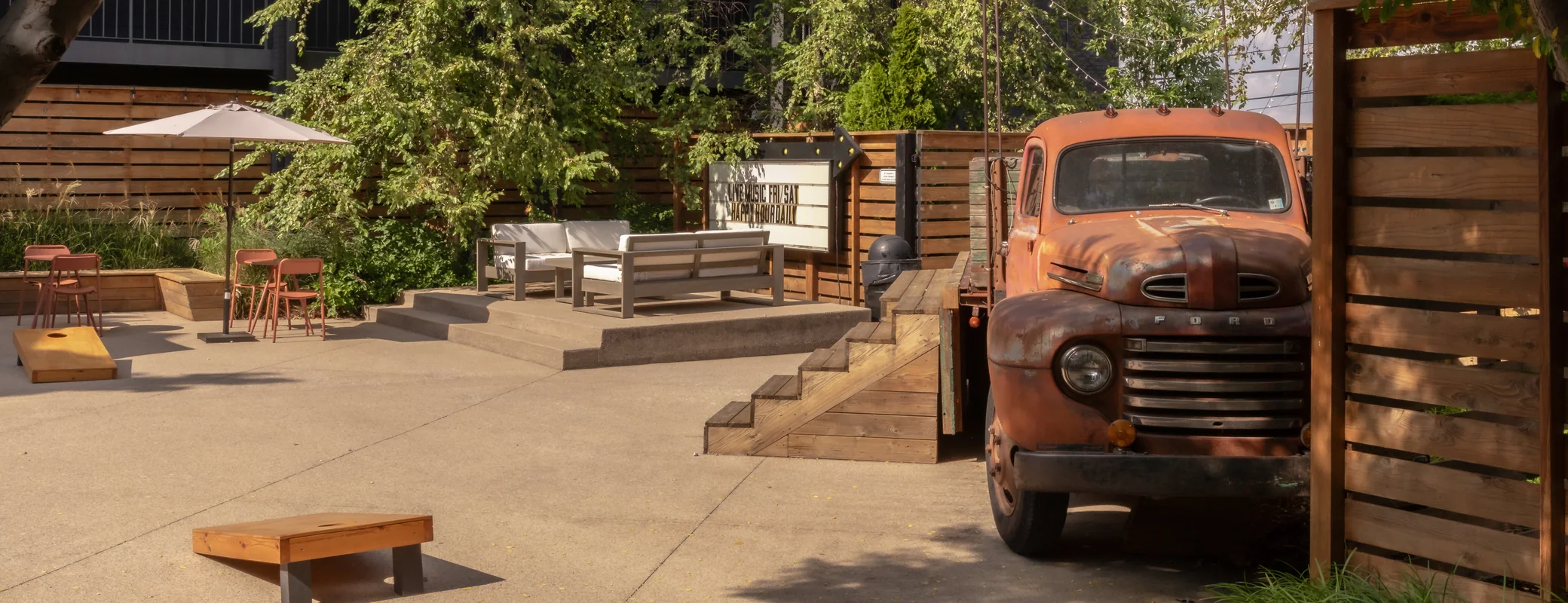 Bode Nashville courtyard with lounge seating, cornhole boards and a vintage Ford truck