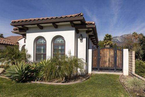 View of Spanish style ADU with round-topped windows shot from the front yard.