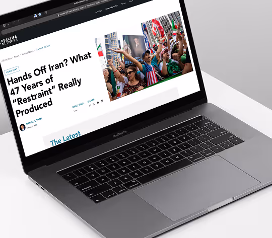 Laptop screen showing news article titled 'Hands Off Iran? What 47 Years of Restraint Really Produced.'