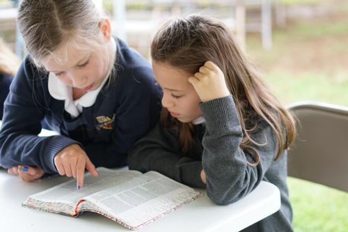 two students reading a book
