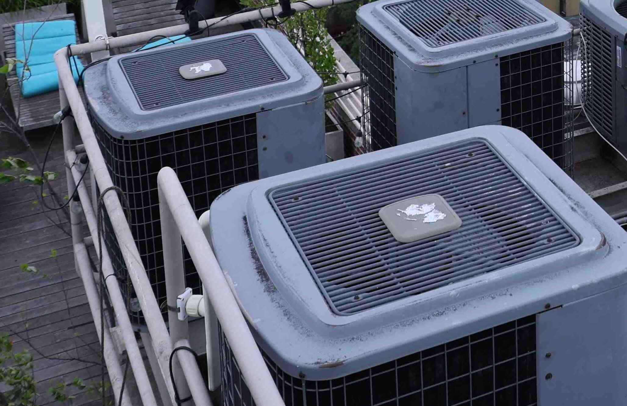 HVAC technician using manifold gauges to test and service an indoor air conditioning unit