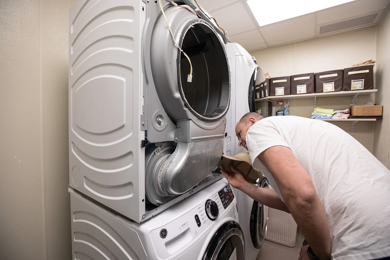 Technician servicing dryer airflow system and internal components