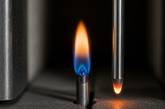 Pilot flame burning next to a thermocouple inside a gas furnace