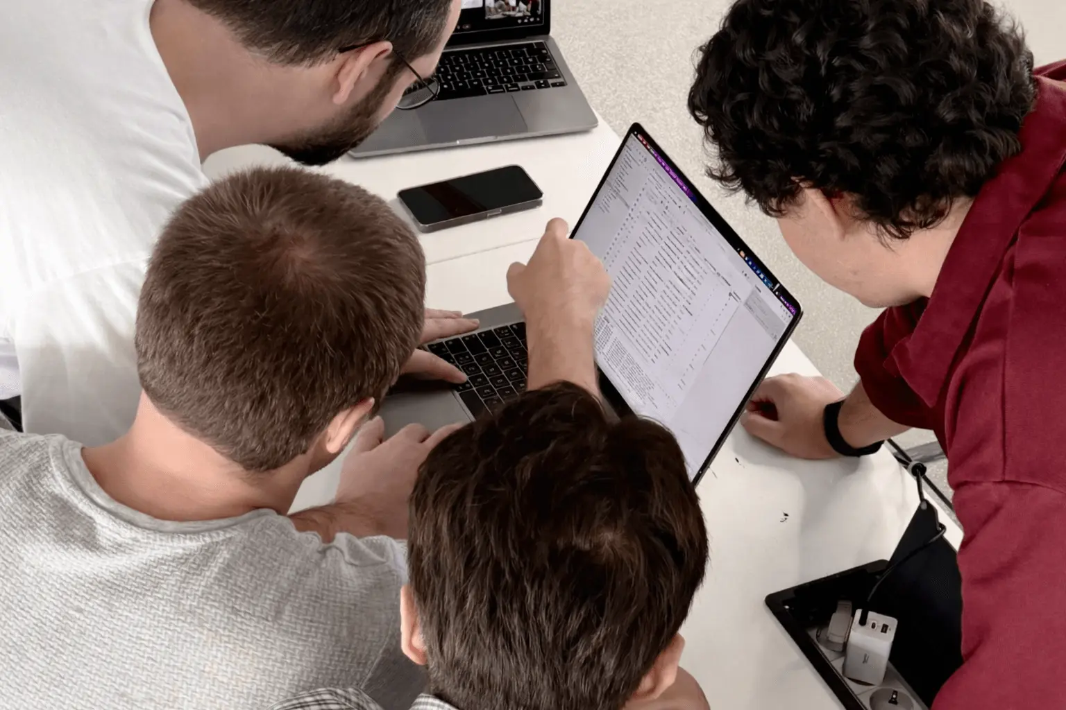 Next Talent 2 participants reviewing code together on a laptop screen.