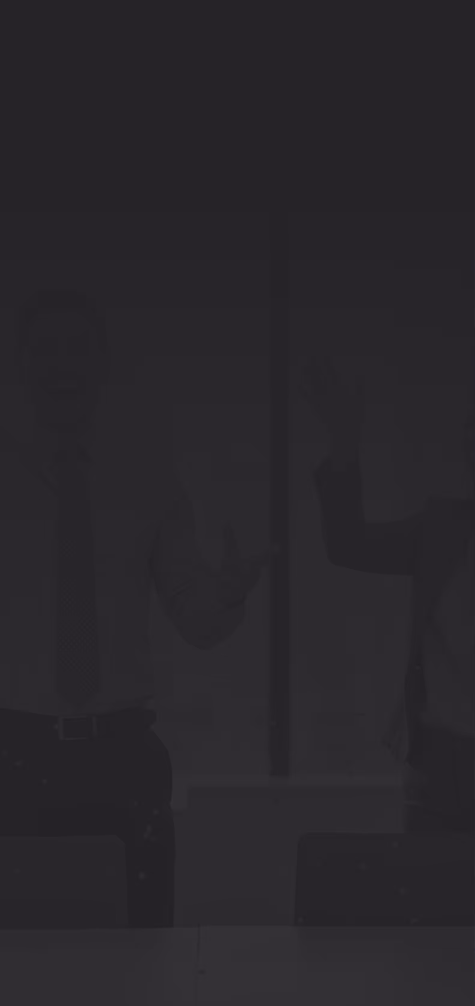 Two businesspeople smiling and raising their fists in a celebratory gesture inside a modern office.