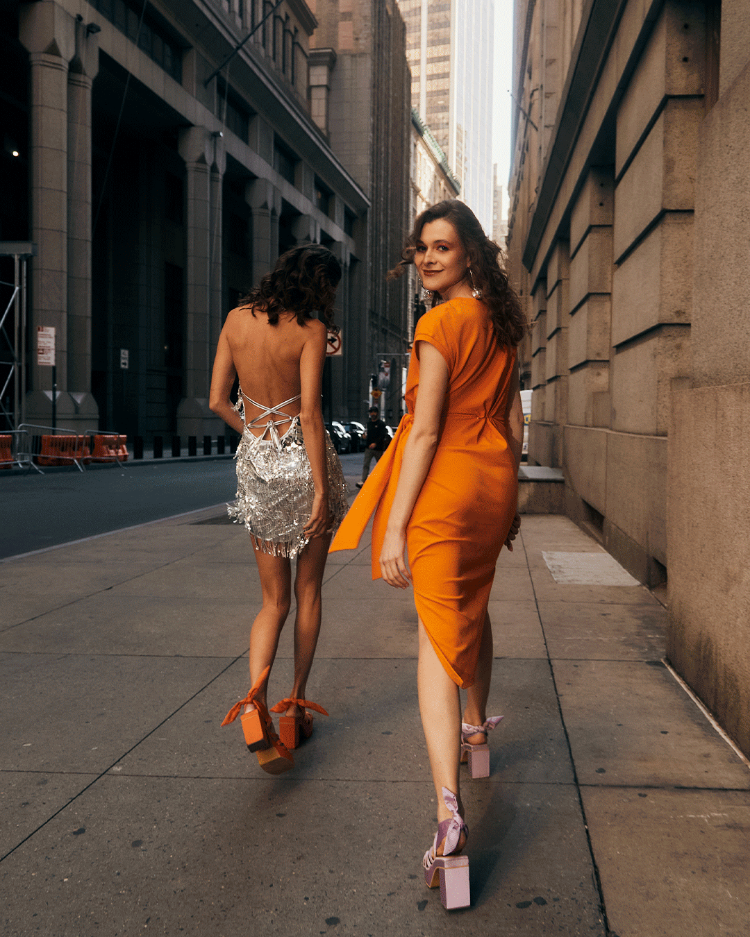 two women walking on a sidewalk