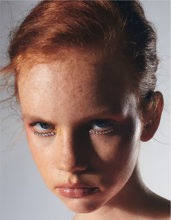 a woman with red hair and rhinestones on her eyes