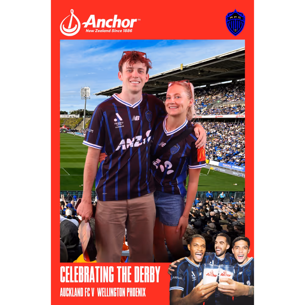 Two fans in blue-striped Auckland FC jerseys smiling at the stadium during Auckland FC vs Wellington Phoenix derby.