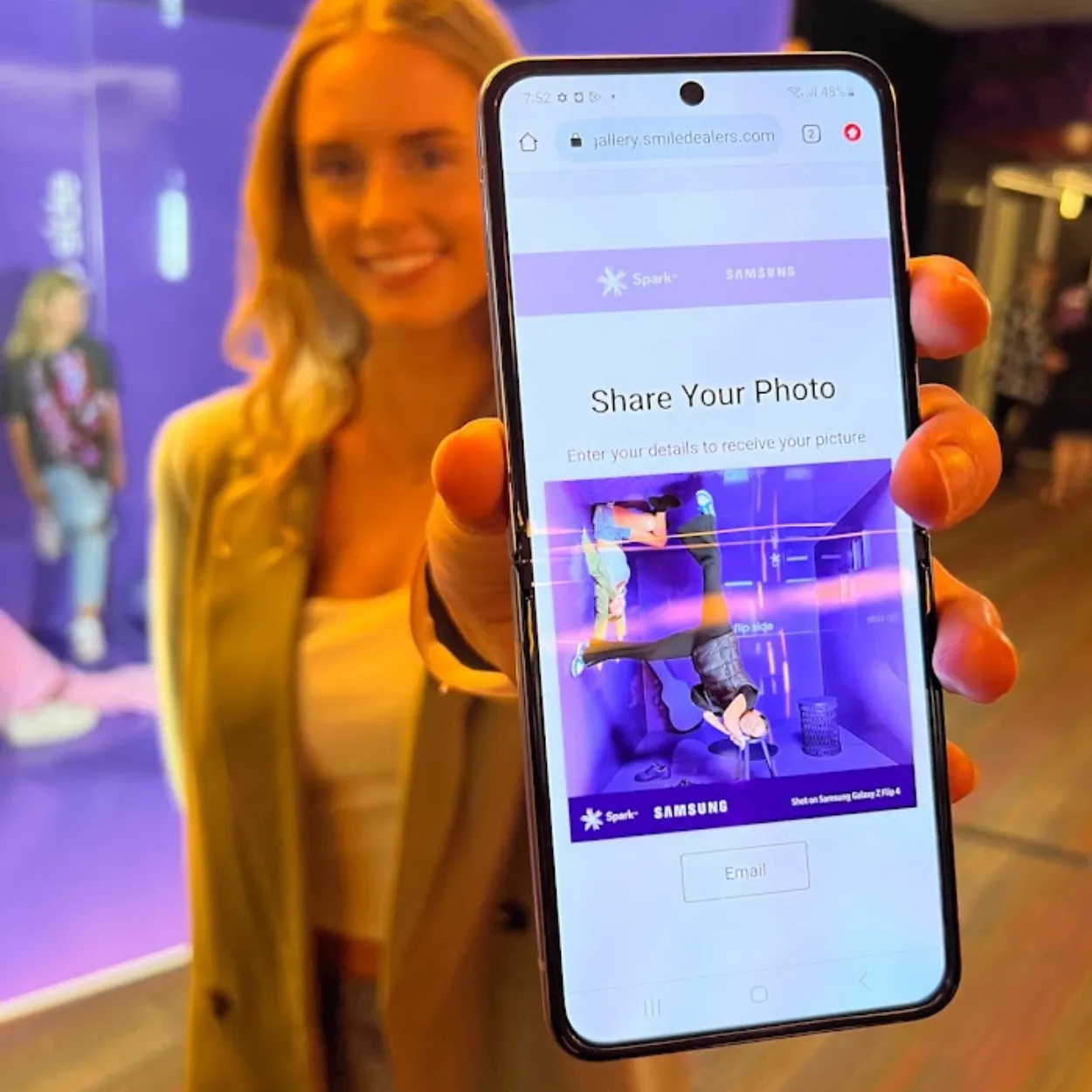 Person holding a phone showing a photo sharing site with an upside-down photo preview.