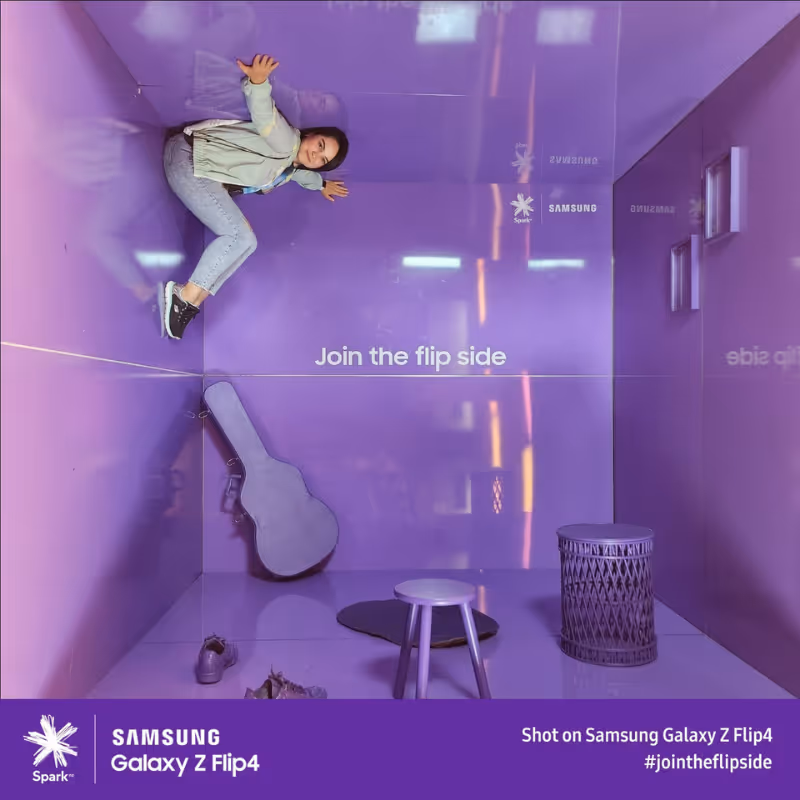 Person appears to walk on a purple wall in a room with guitar case and stool, text says Join the flip side.